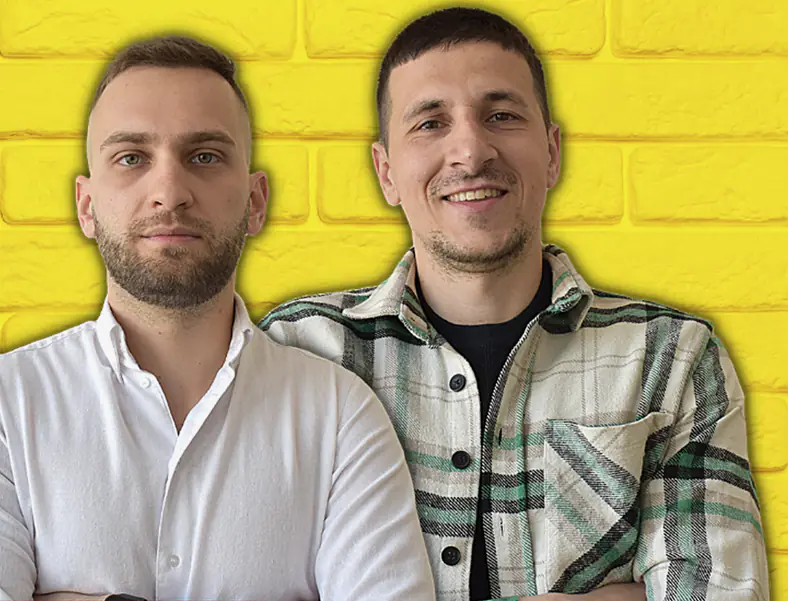 Илия и Цветомир, основателите на Quiz BG, пред жълта тухлена стена